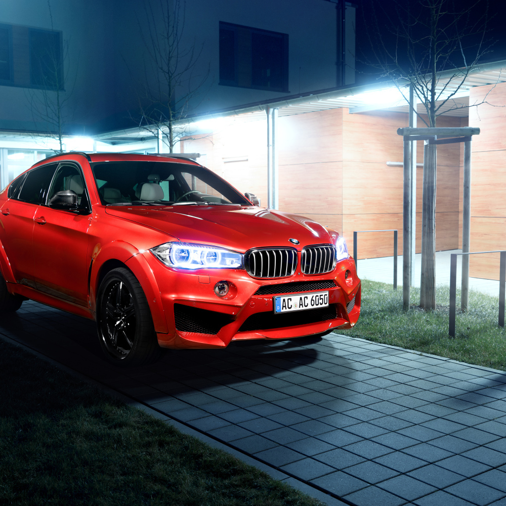 Красный автомобиль BMW X6 на тротуаре