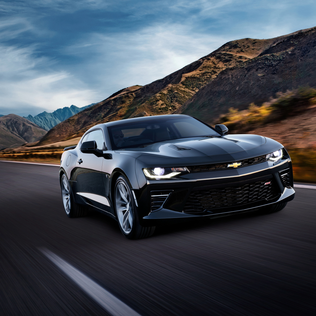 Черный быстрый автомобиль Chevrolet Camaro SS, 2018 года на трассе у гор