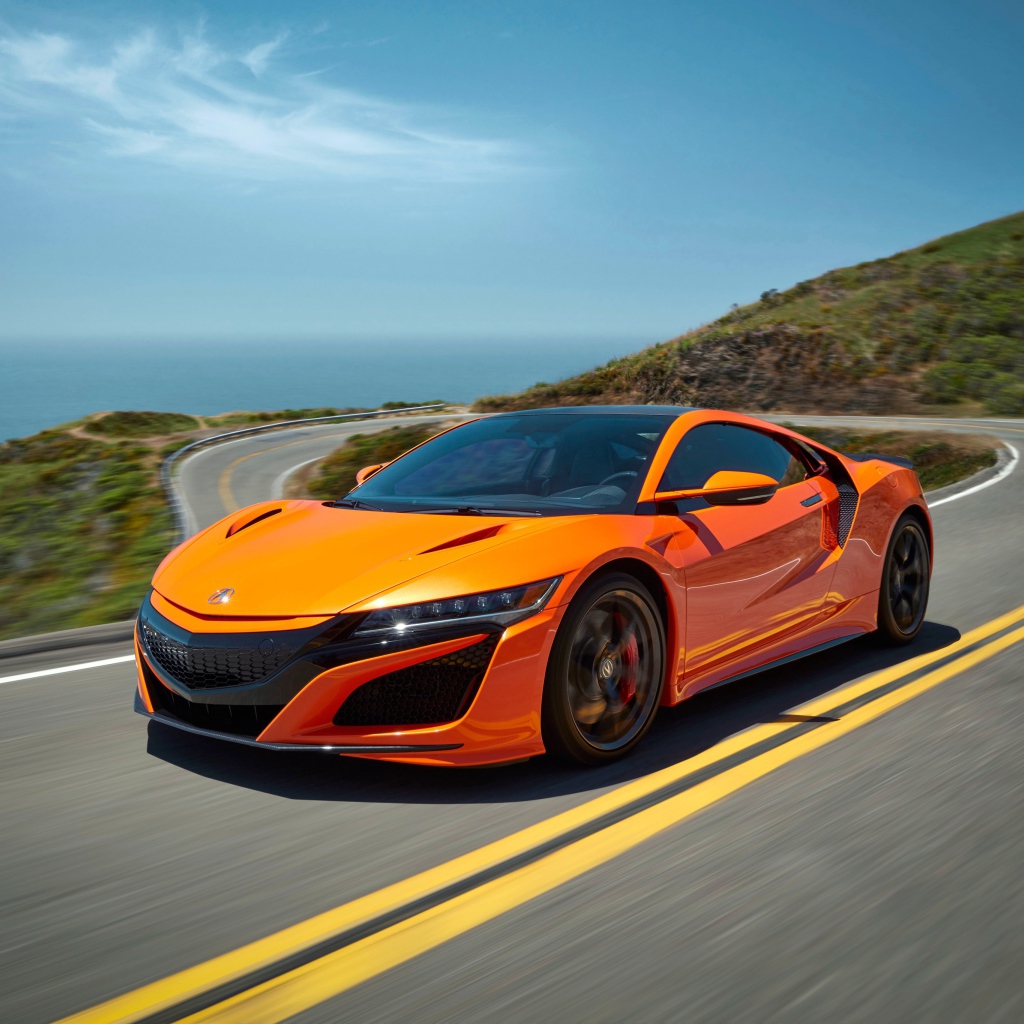 Оранжевый автомобиль Honda NSX на трассе под голубым небом
