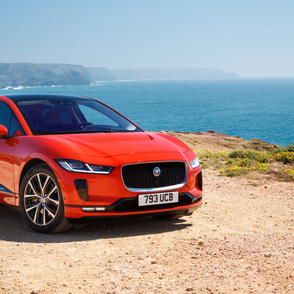 Красный Jaguar I-Pace EV400 AWD HSE First Edition 2018 года на фоне океана 