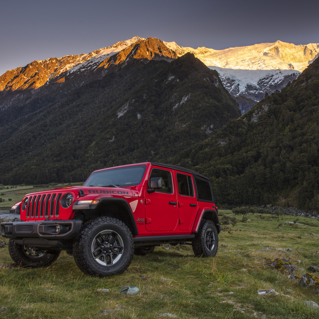 Красный автомобиль Jeep Wrangler на фоне гор