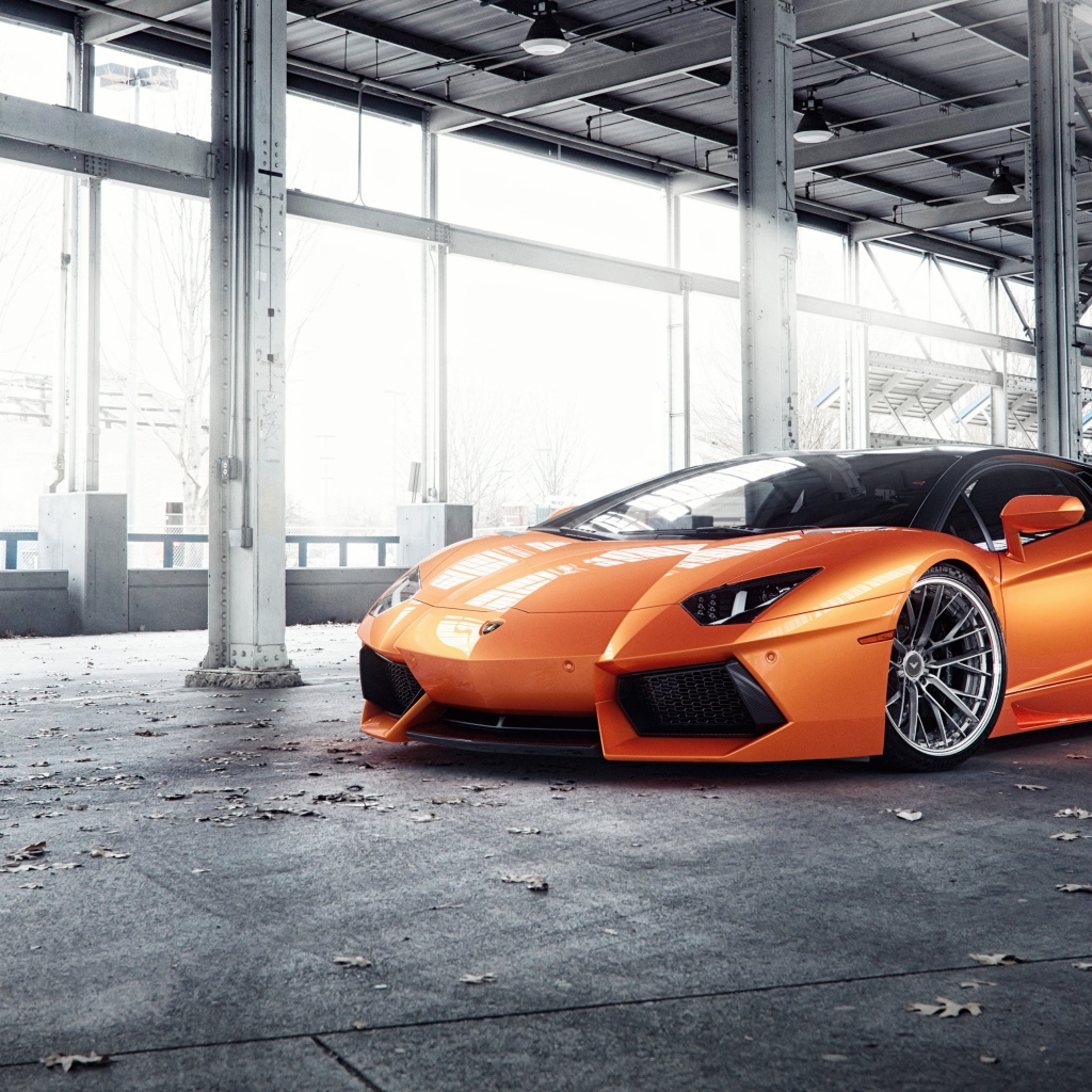 Оранжевый автомобиль Lamborghini Aventador под мостом