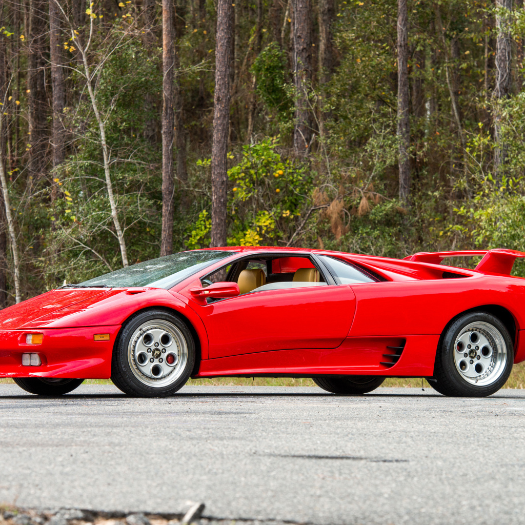 Красный спортивный автомобиль Lamborghini Diablo на фоне леса