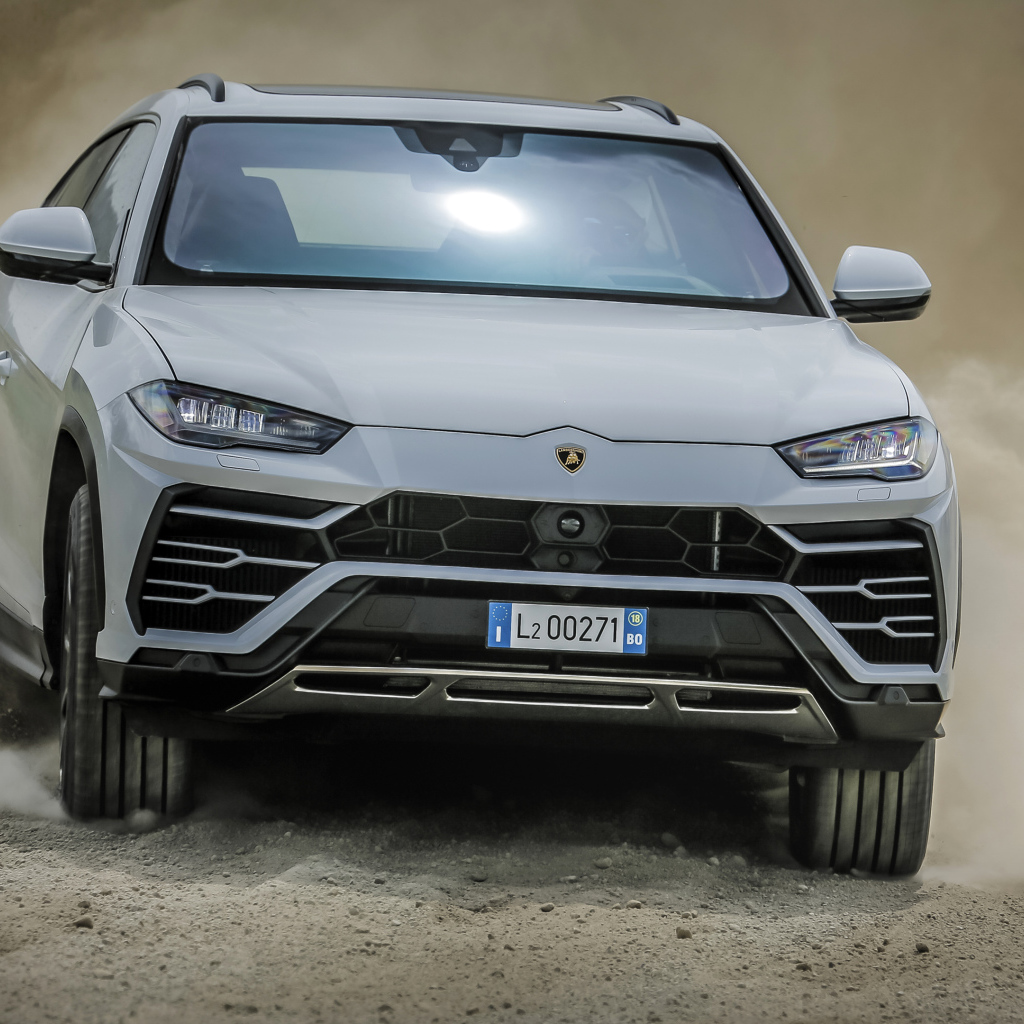 Белый автомобиль Lamborghini Urus  2018 года едет по дороге 