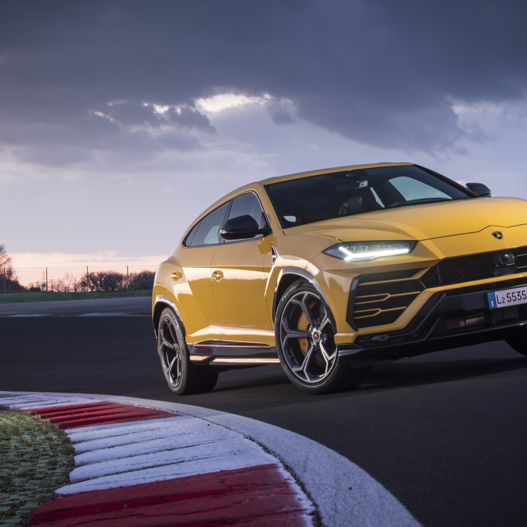 Желтый внедорожник Lamborghini Urus  едет по дороге