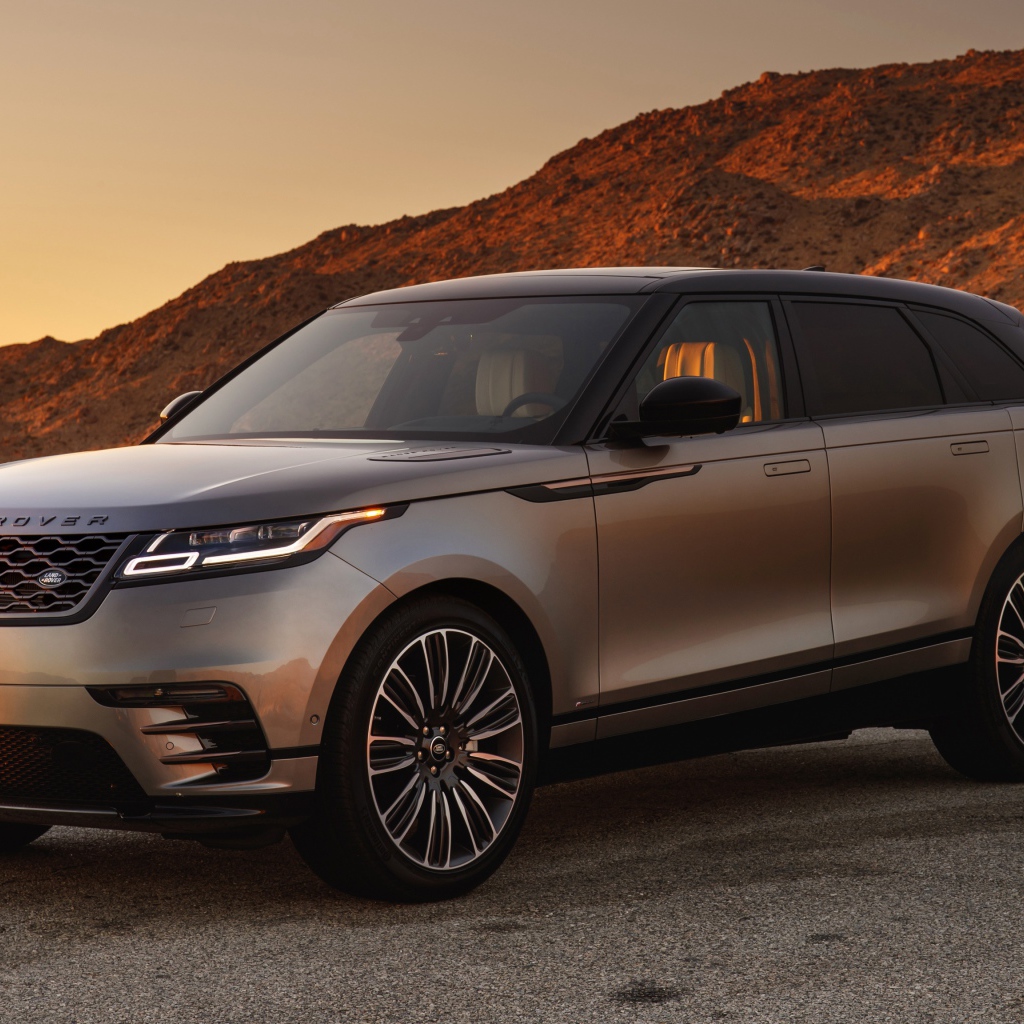 Серебристый внедорожник Land Rover 2018 года на фоне скалы 