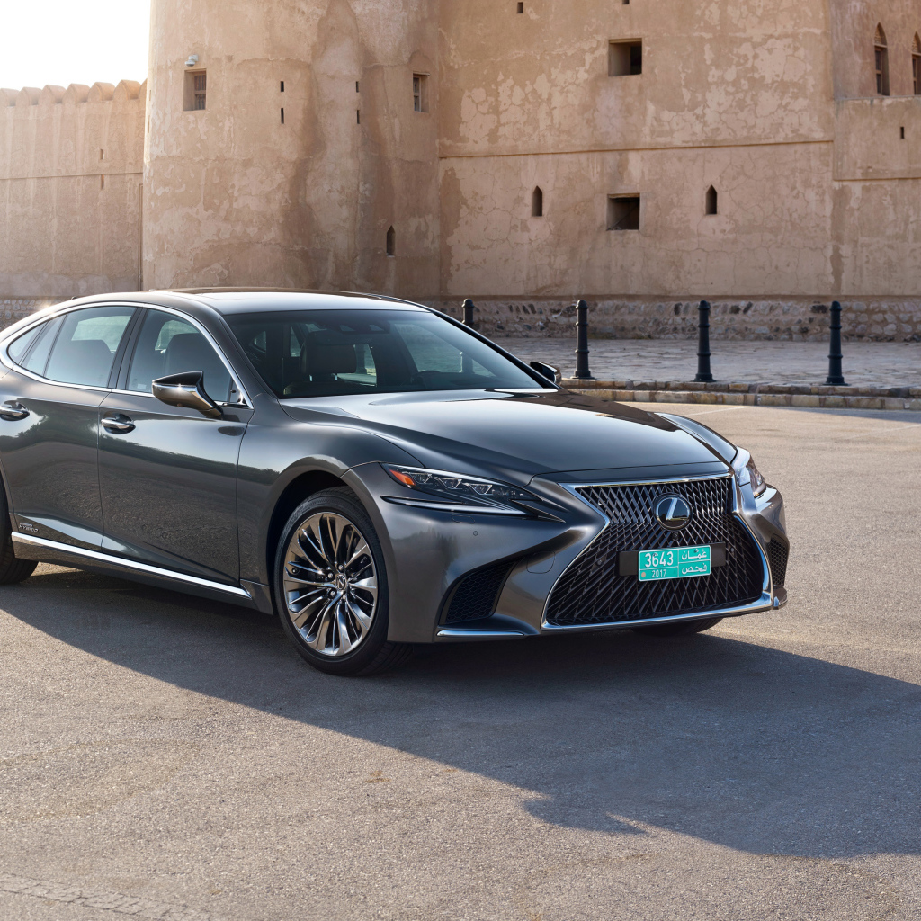 Стильный автомобиль Lexus LS 500h AWD, 2018 на фоне крепости