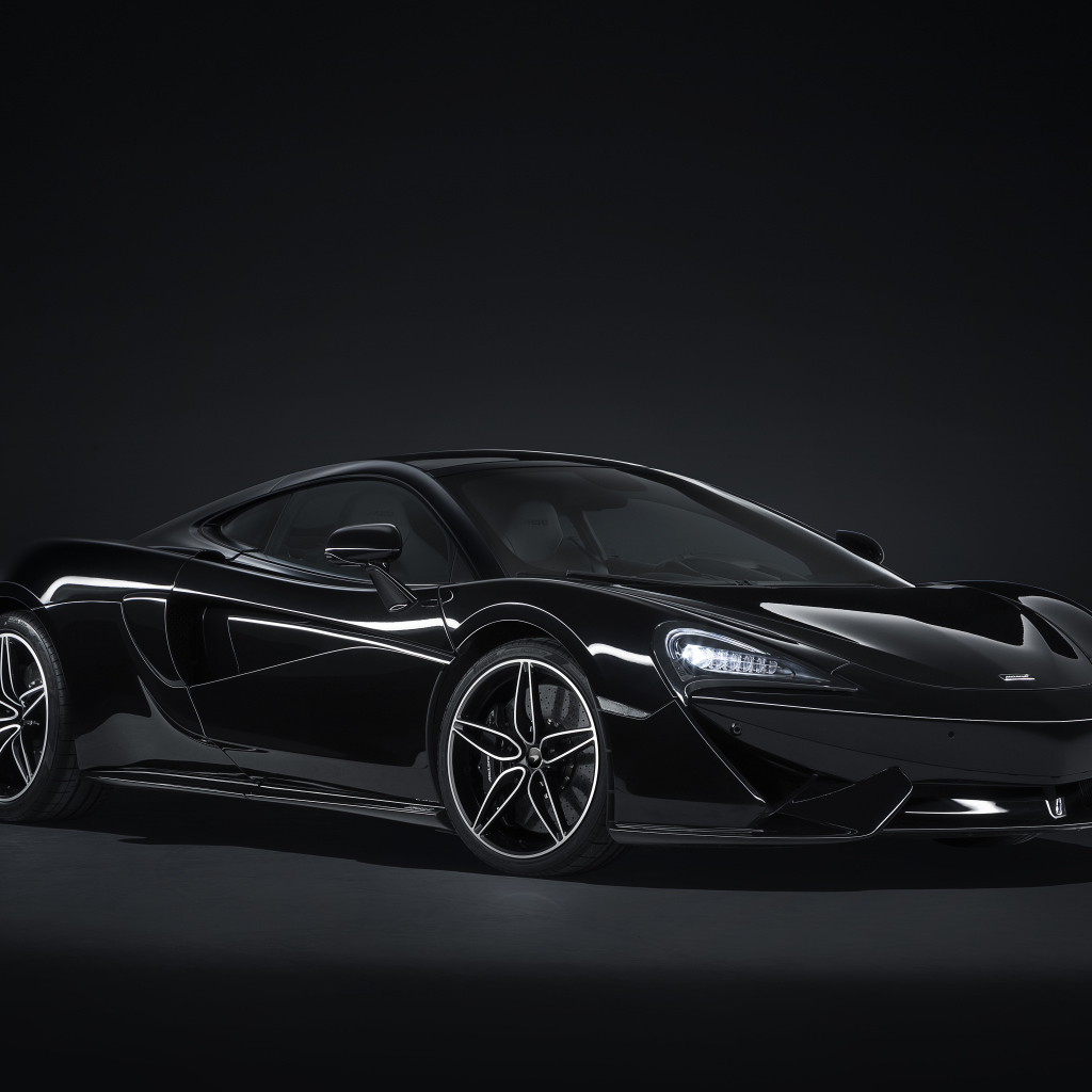 Черный автомобиль McLaren 570GT на сером фоне