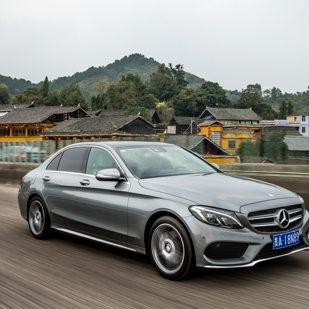 Серебристый автомобиль Mercedes-Benz C-Class на трассе