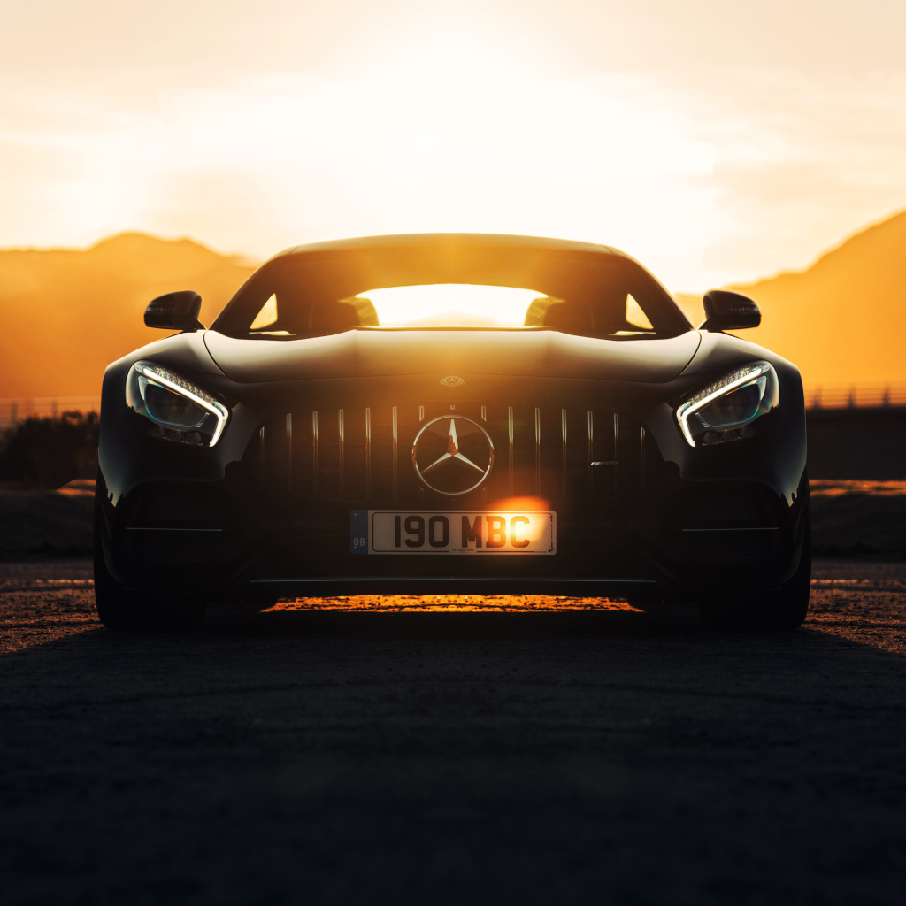 Стильный черный автомобиль Mercedes-AMG GT C на фоне заката