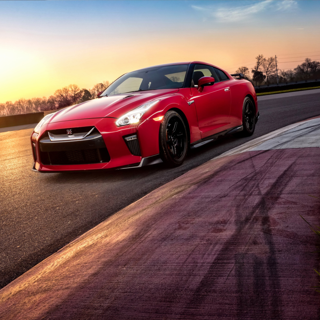 Красный автомобиль Nissan GT-R 2018 года на трассе на закате
