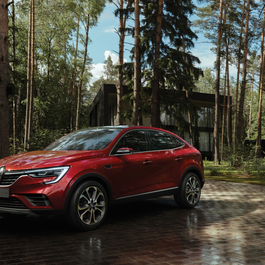 Red stylish SUV Renault Arkana, 2018 in the forest
