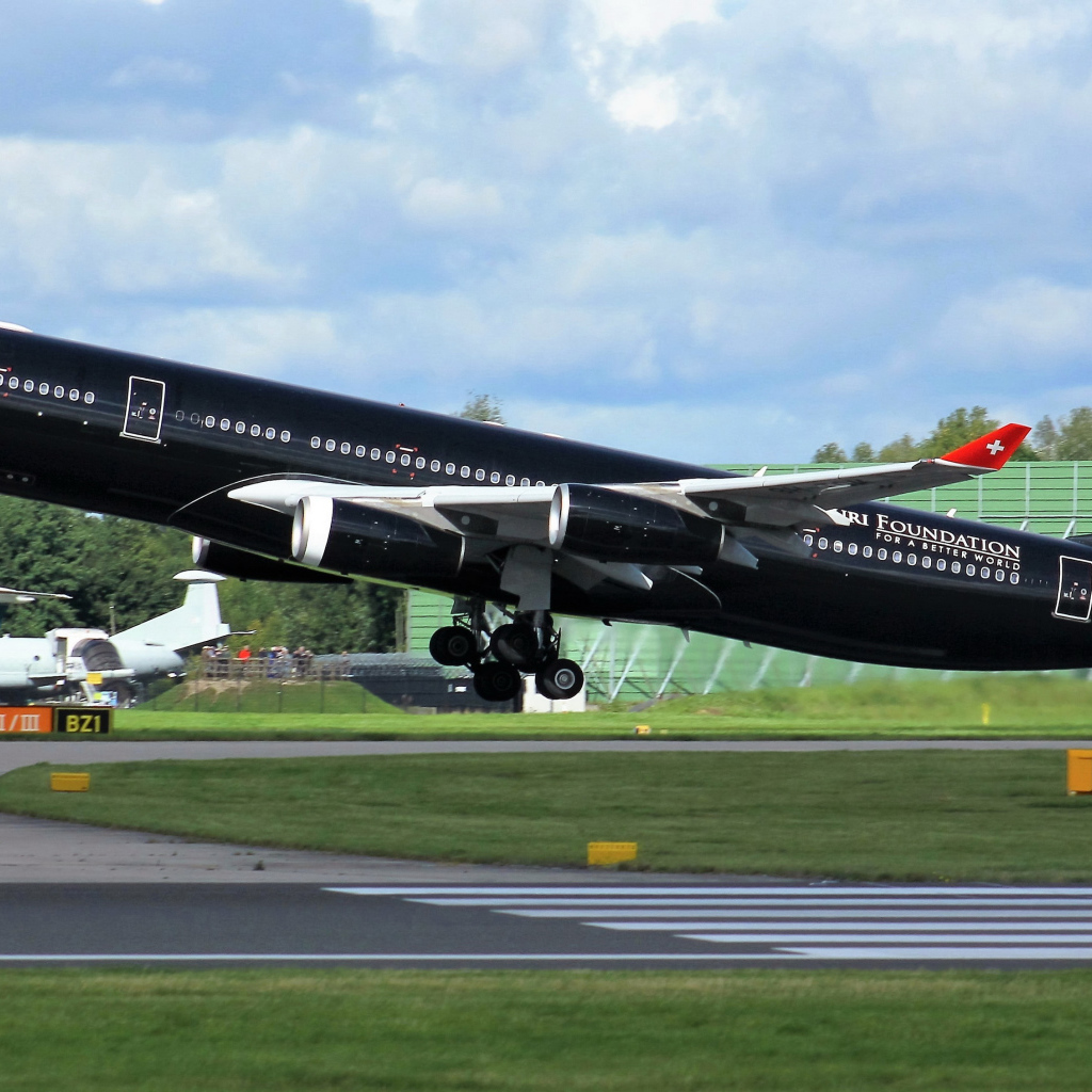 Black passenger airplane Airbus A340-313 on take-off