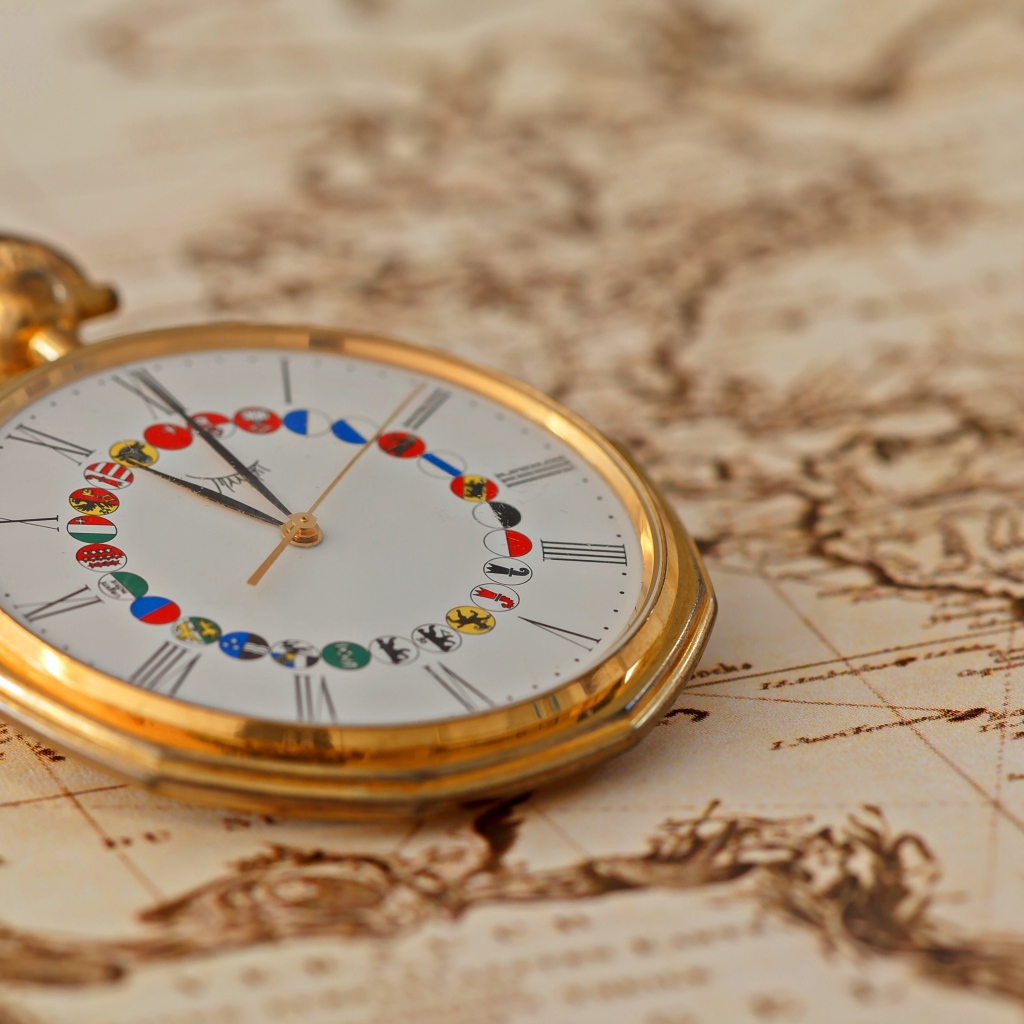 Карманные часы в золотой оправе лежат на карте