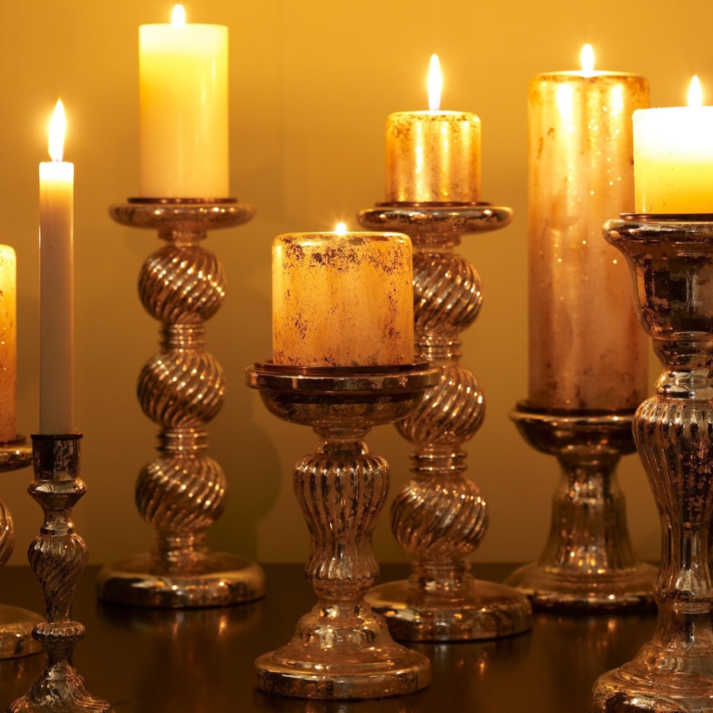 Старинные подсвечники с зажженными свечами на столе 