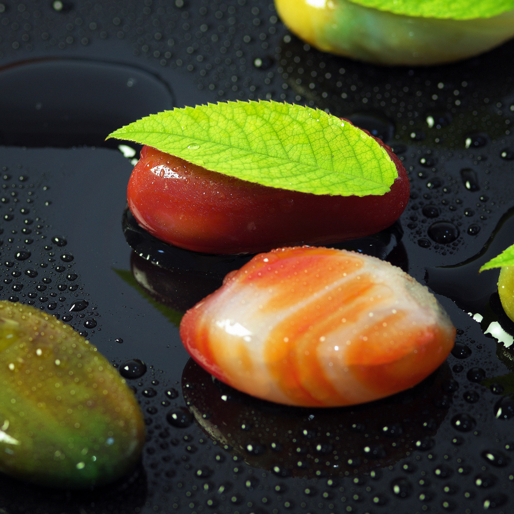 Красивые камни на черной мокрой поверхности