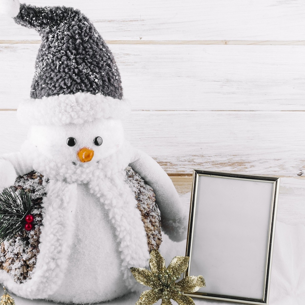 Большой игрушечный снеговик на деревянном фоне