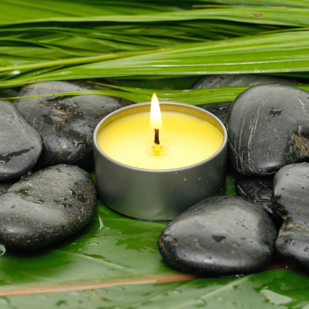 Зажженная свеча и черные камни для SPA