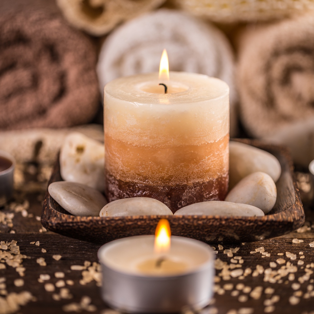 Зажженная свеча с камнями для SPA процедур