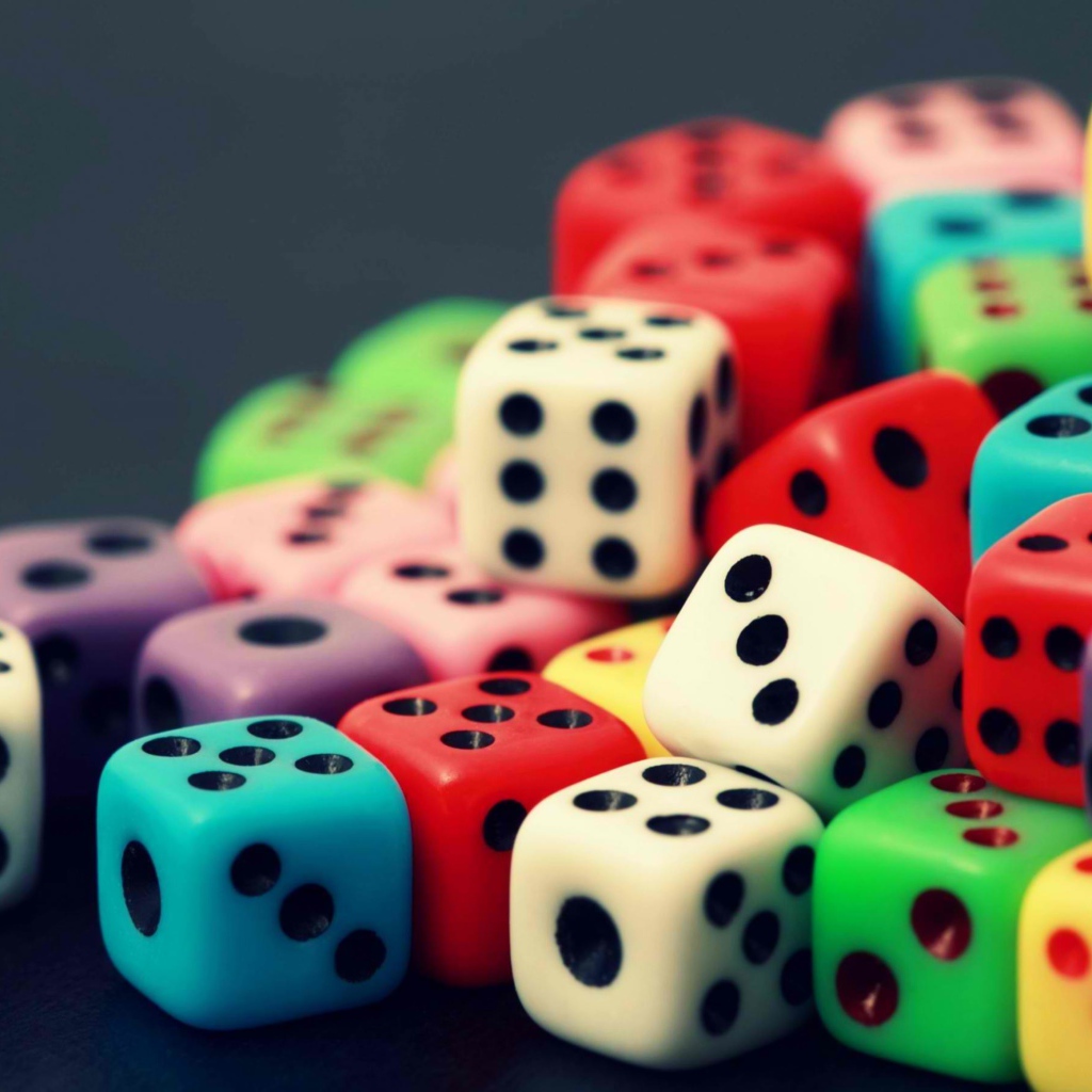 Разноцветные игральные кости на сером столе 