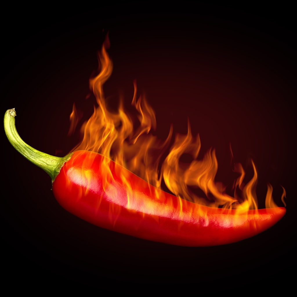 Красный перец с пламенем на черном фоне