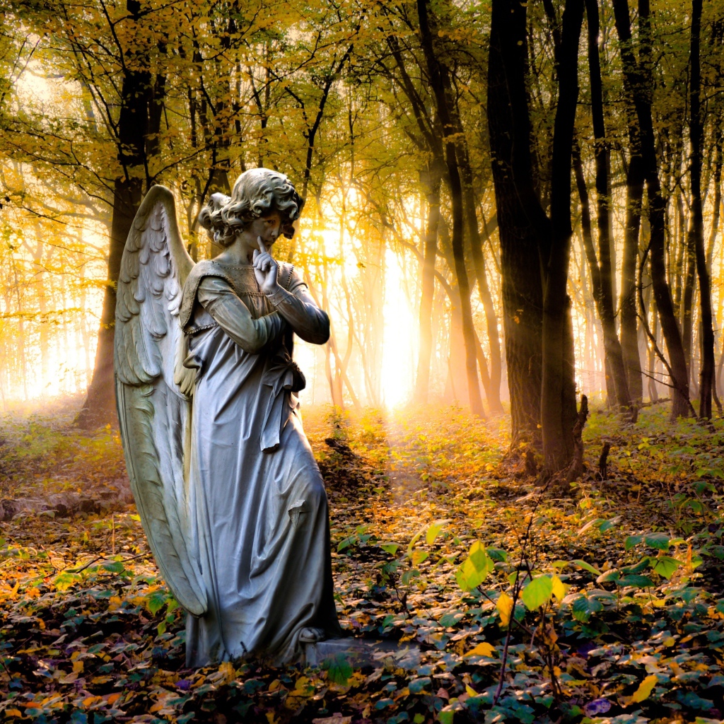 Статуя ангела в лесу в лучах солнца