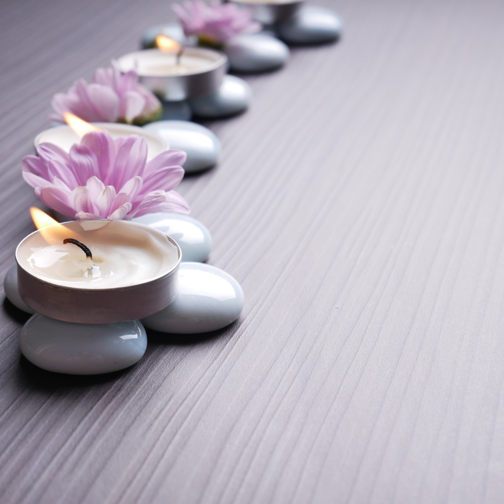 Камни с ароматическими свечами и цветами хризантемы