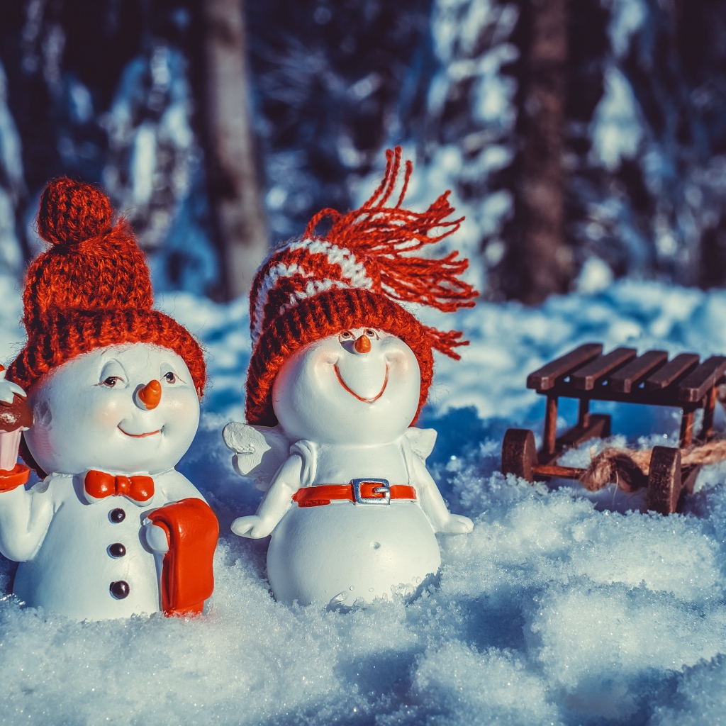 Две статуэтки снеговиков на снегу