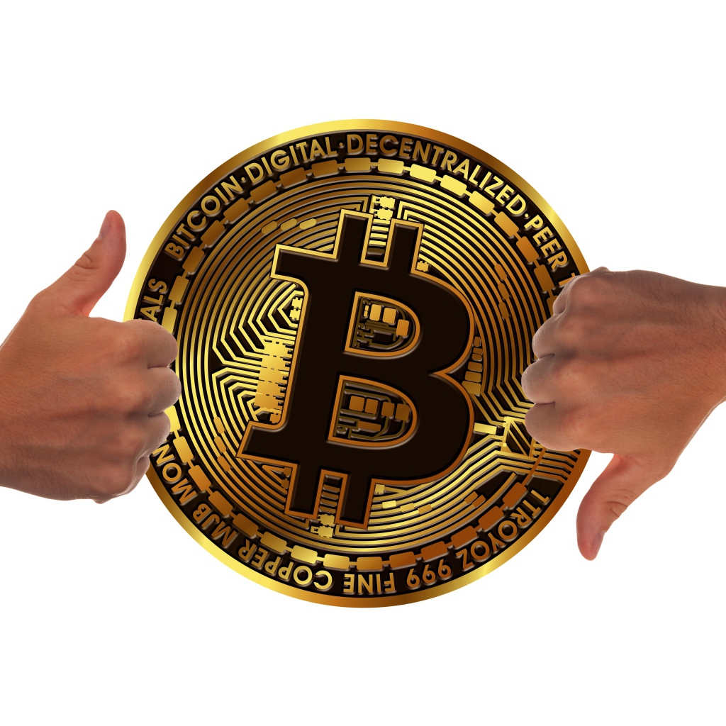 Две руки оценивают монету биткоин на белом фоне