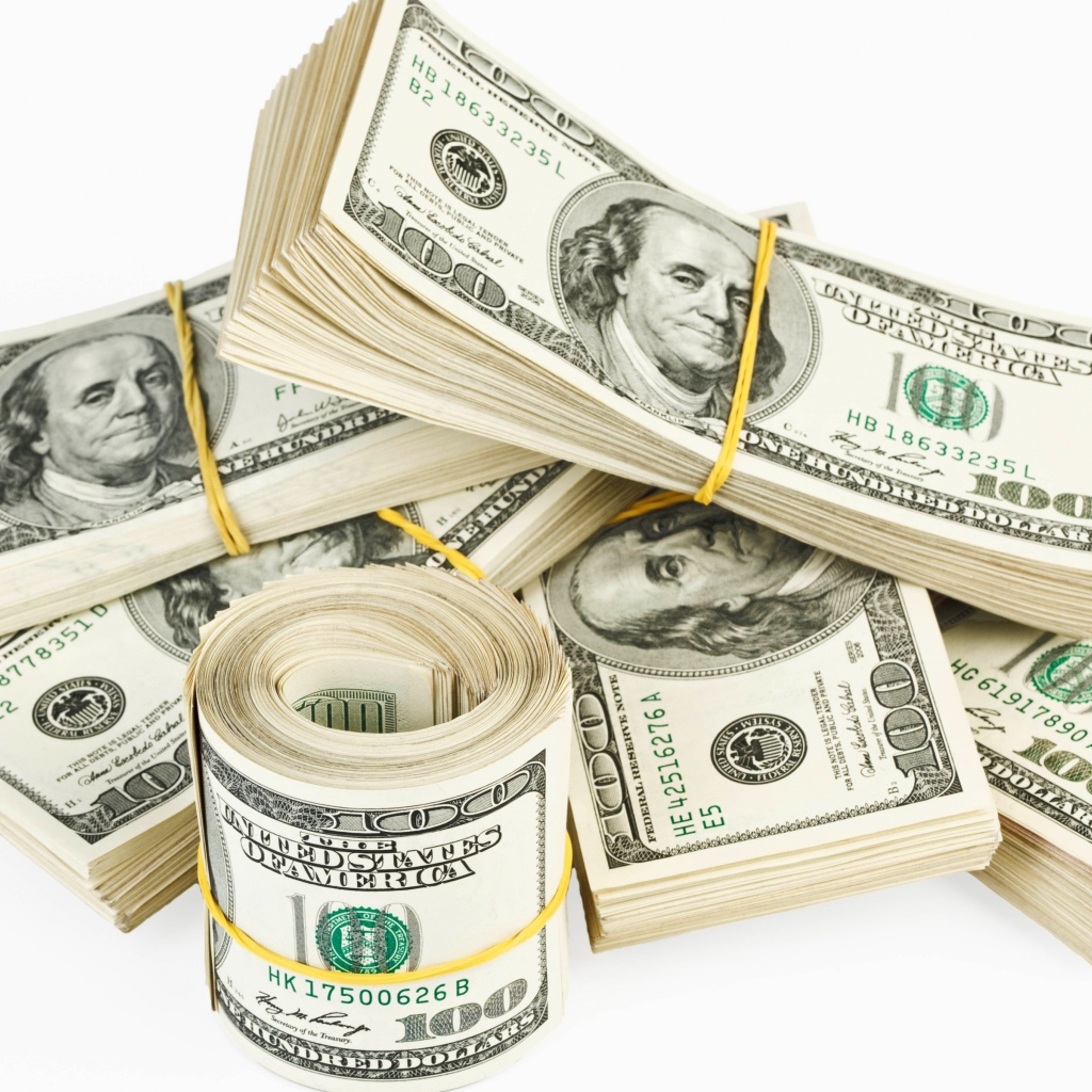Пачки банкнот по сто долларов на белом фоне