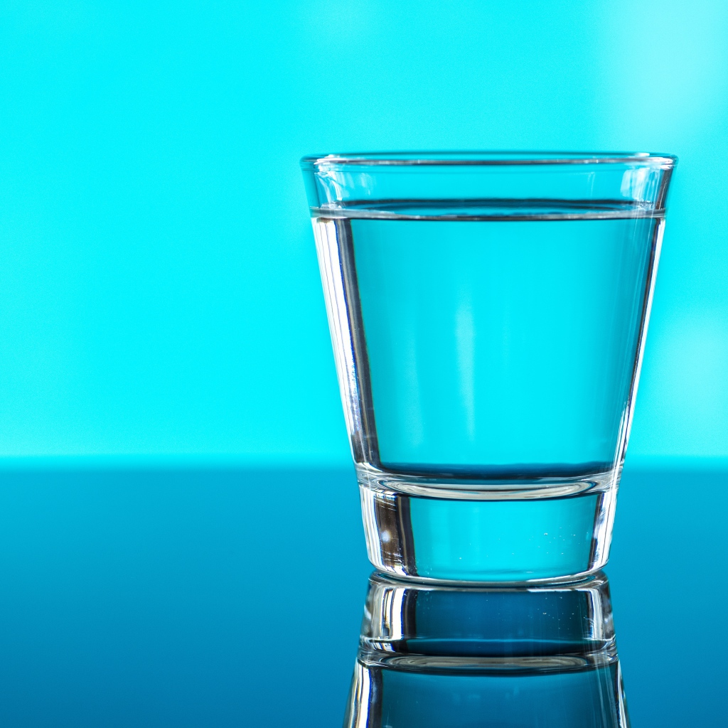 Стакан воды на голубом фоне 