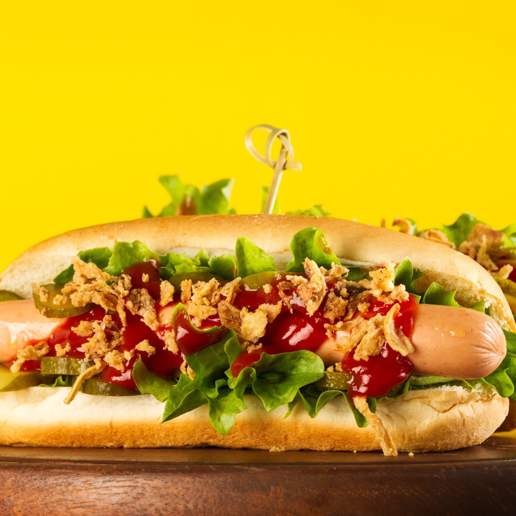 Аппетитные хотдоги на желтом фоне крупным планом