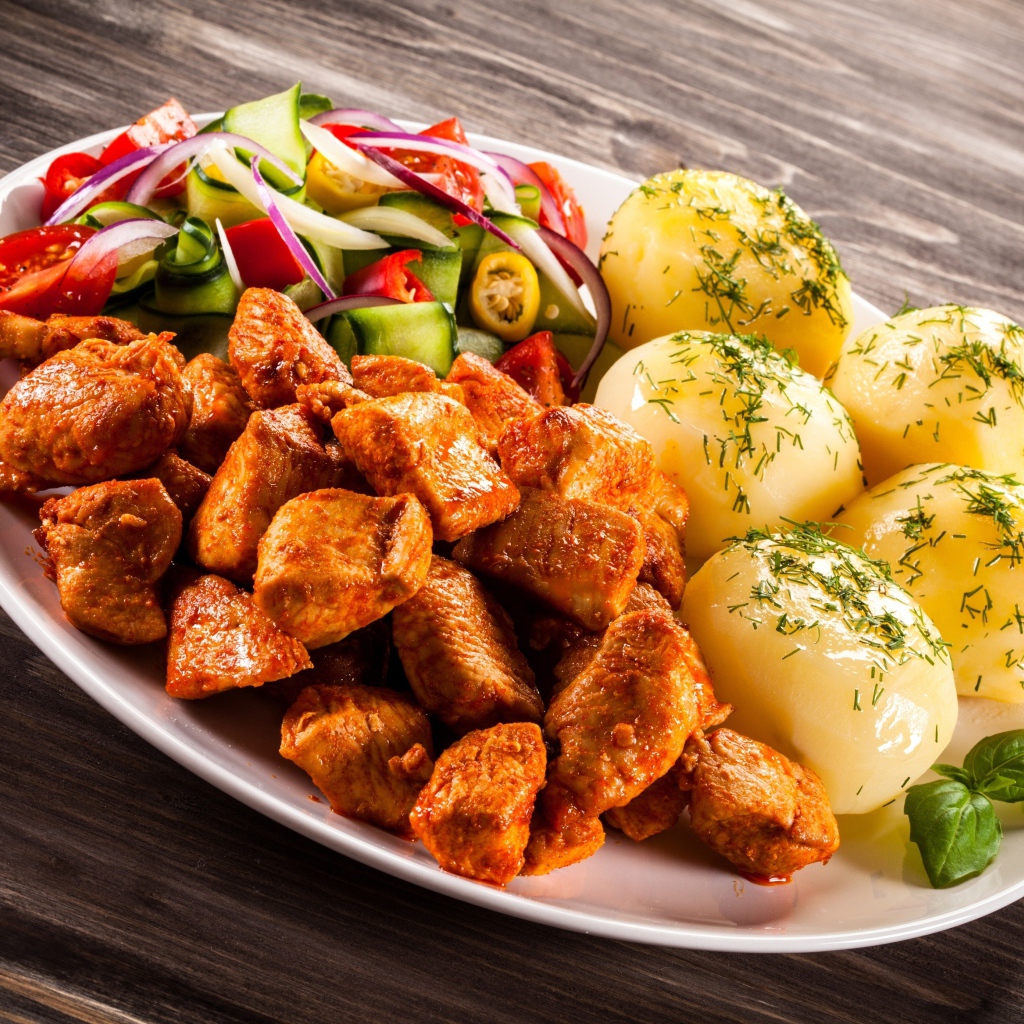 Вареный картофель с мясом и салатом на тарелке