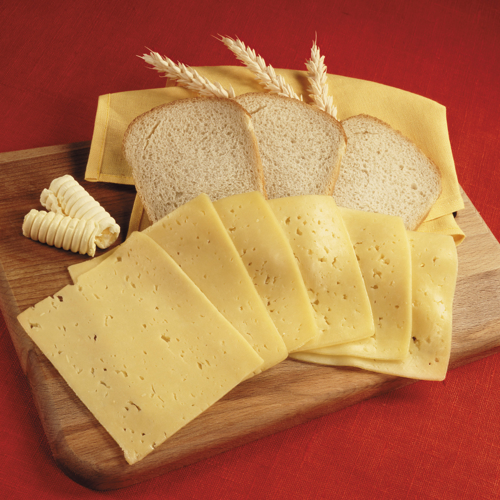 Хлеб с кусками сыра на разделочной доске