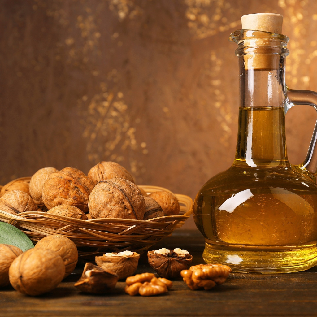 Butter in a glass bottle on a table with walnuts