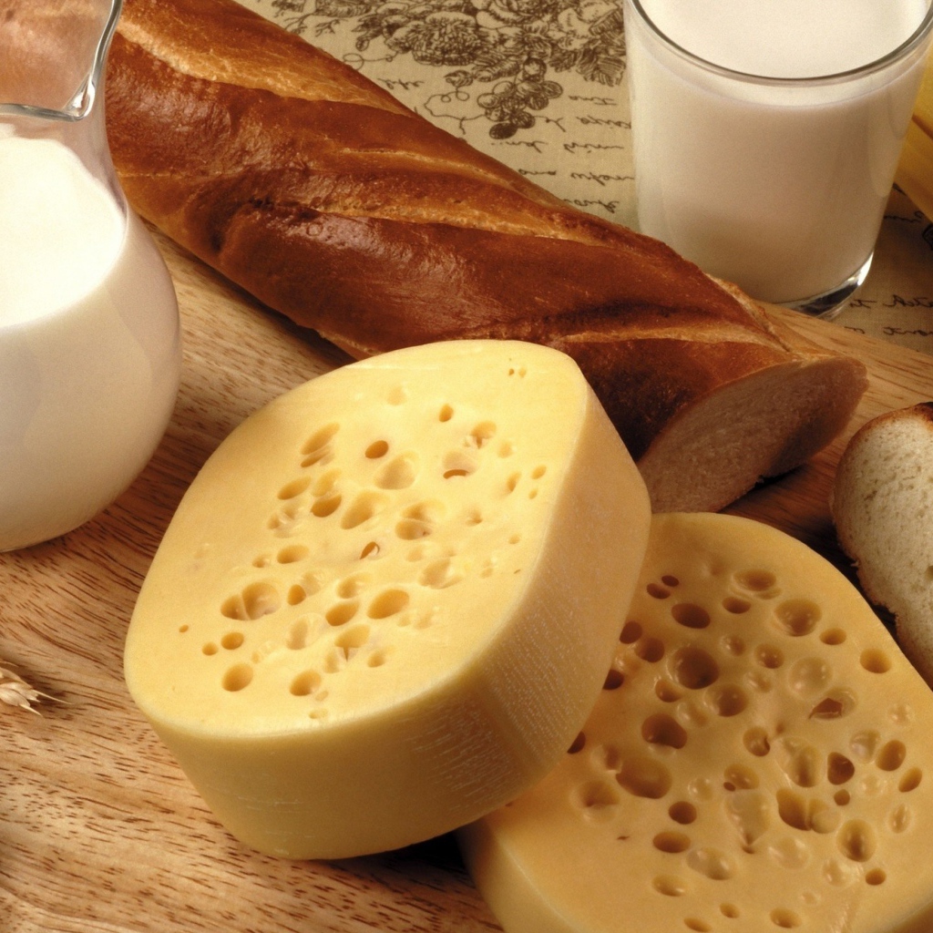 Сыр на столе с маслом, молоком и батоном 