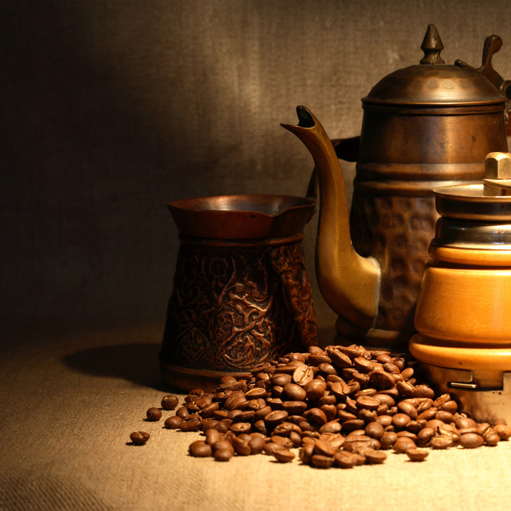 Кофемолка, турка, чайник и кофейные зерна на столе