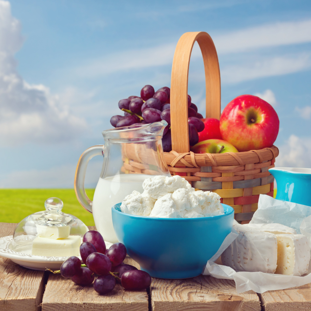 Творог с молоком на столе с виноградом и яблоками 
