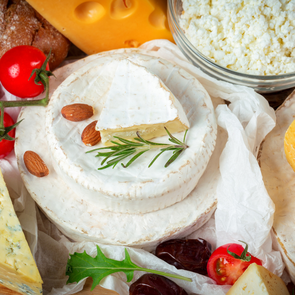 Разные виды сыра на столе с помидорами 