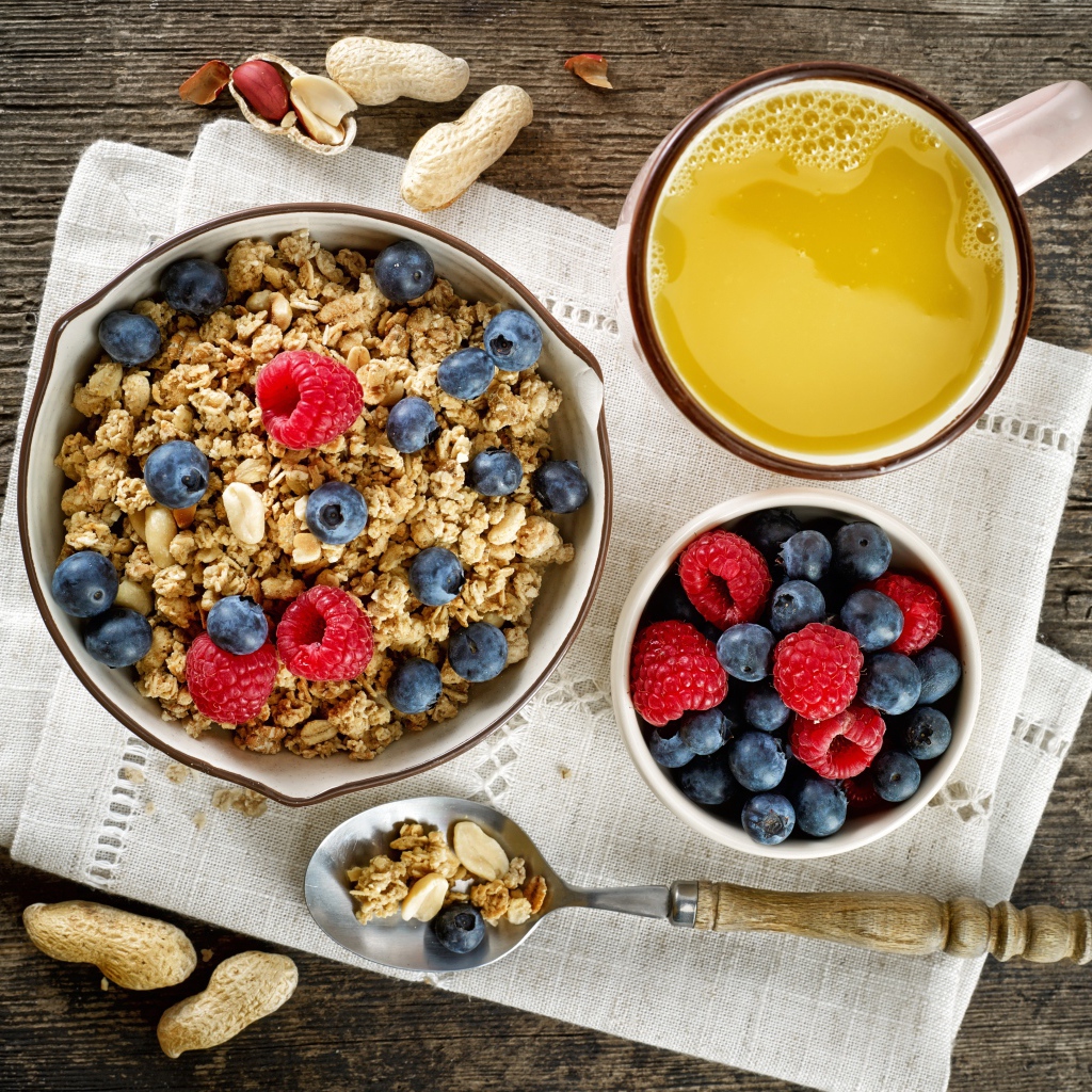 Хлопья с ягодами на столе с соком