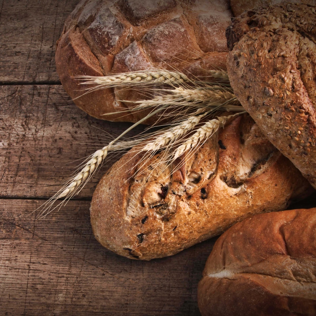 Свежий хлеб на столе с колосьями пшеницы