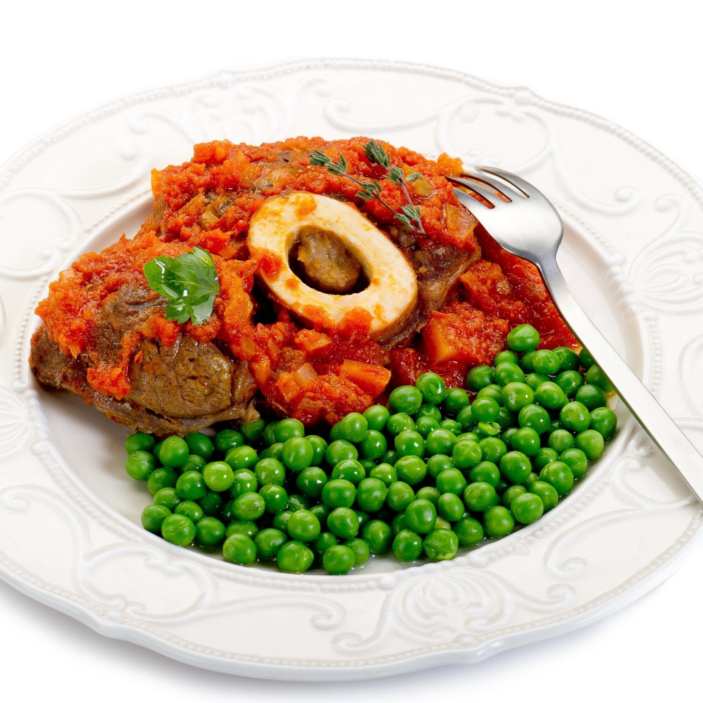 Зеленый горошек на белой тарелке с мясом