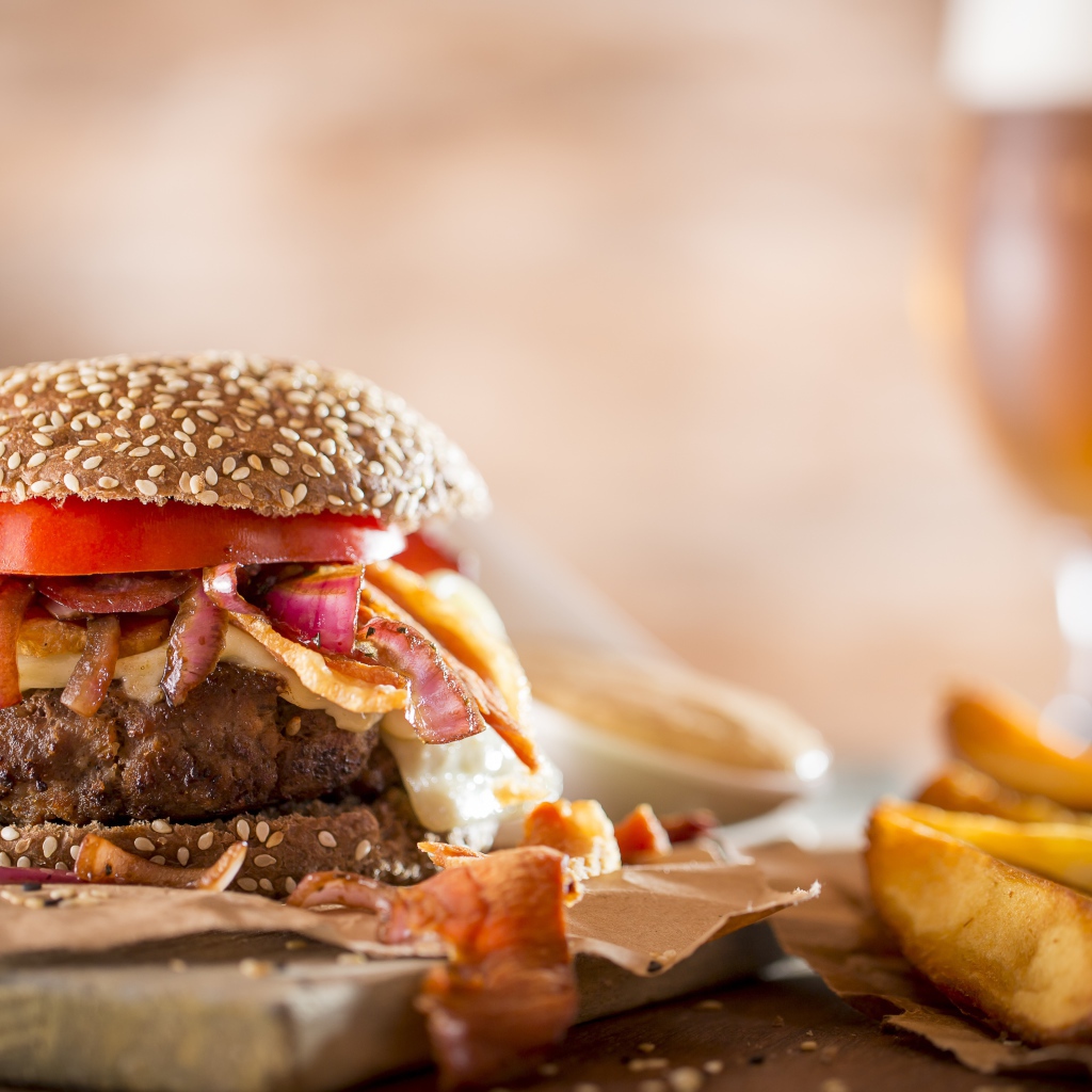 Гамбургер на столе с картофелем и бокалом пива