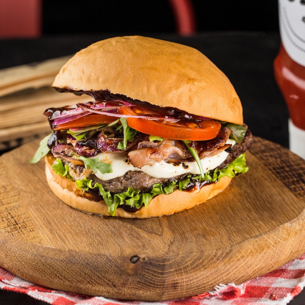 Большой аппетитный гамбургер на деревянной доске 