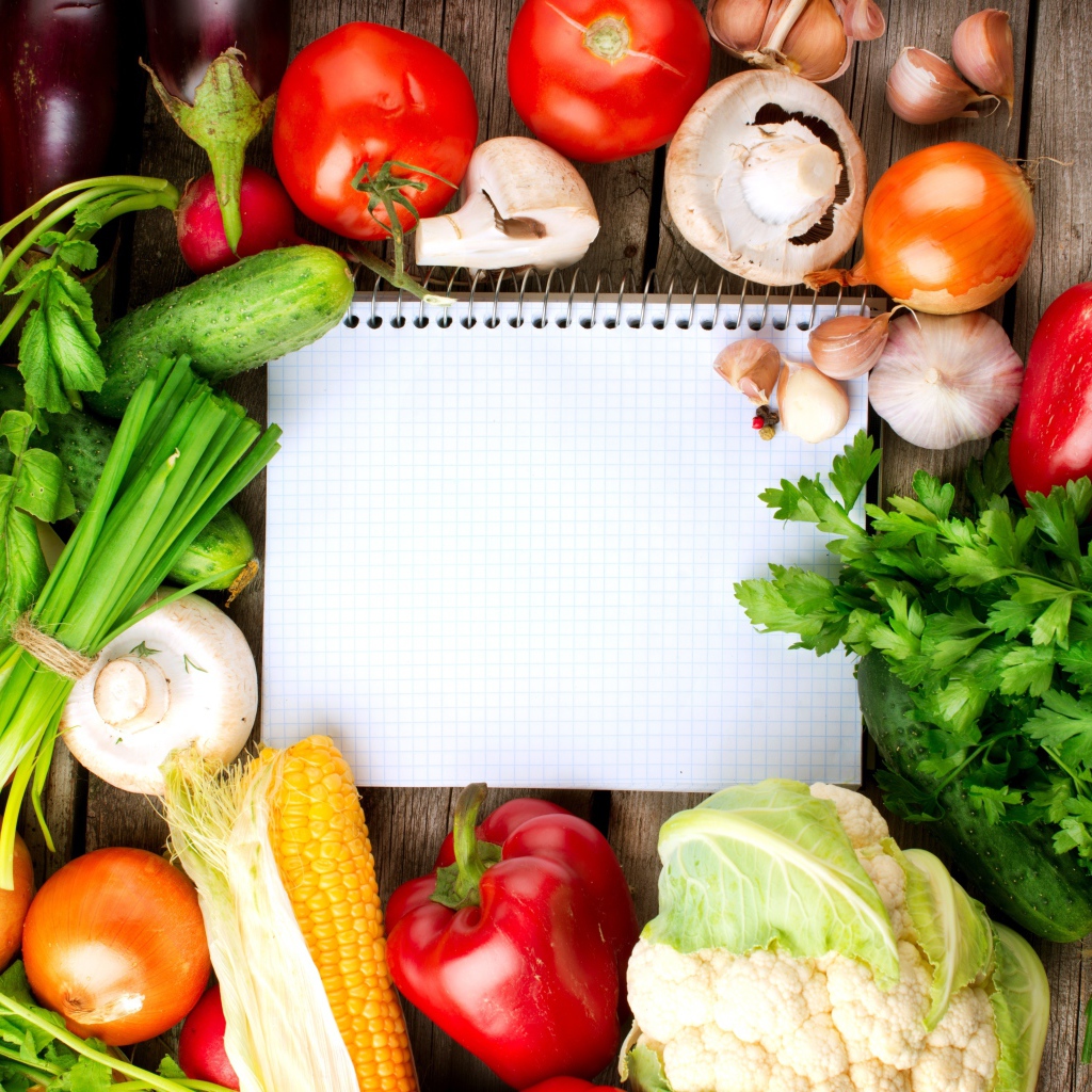 Блокнот со свежими овощами на столе 