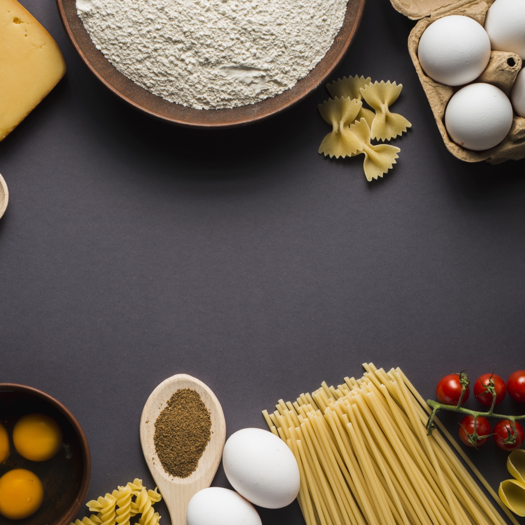 Паста, яйца, специи и помидоры на сером фоне