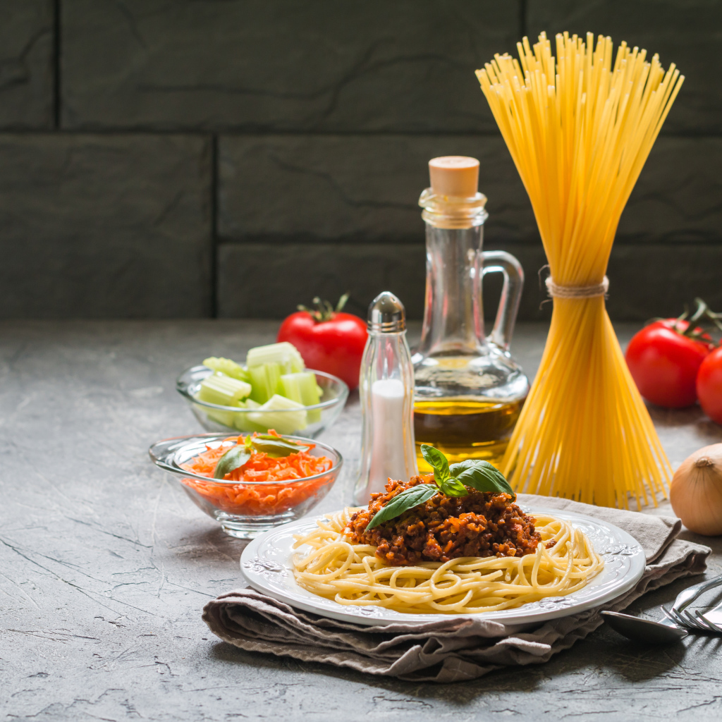 Паста с гарниром на столе с овощами и маслом