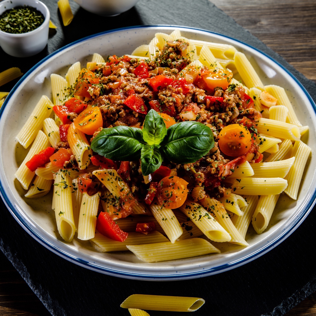 Макароны с фаршем и помидорами на столе