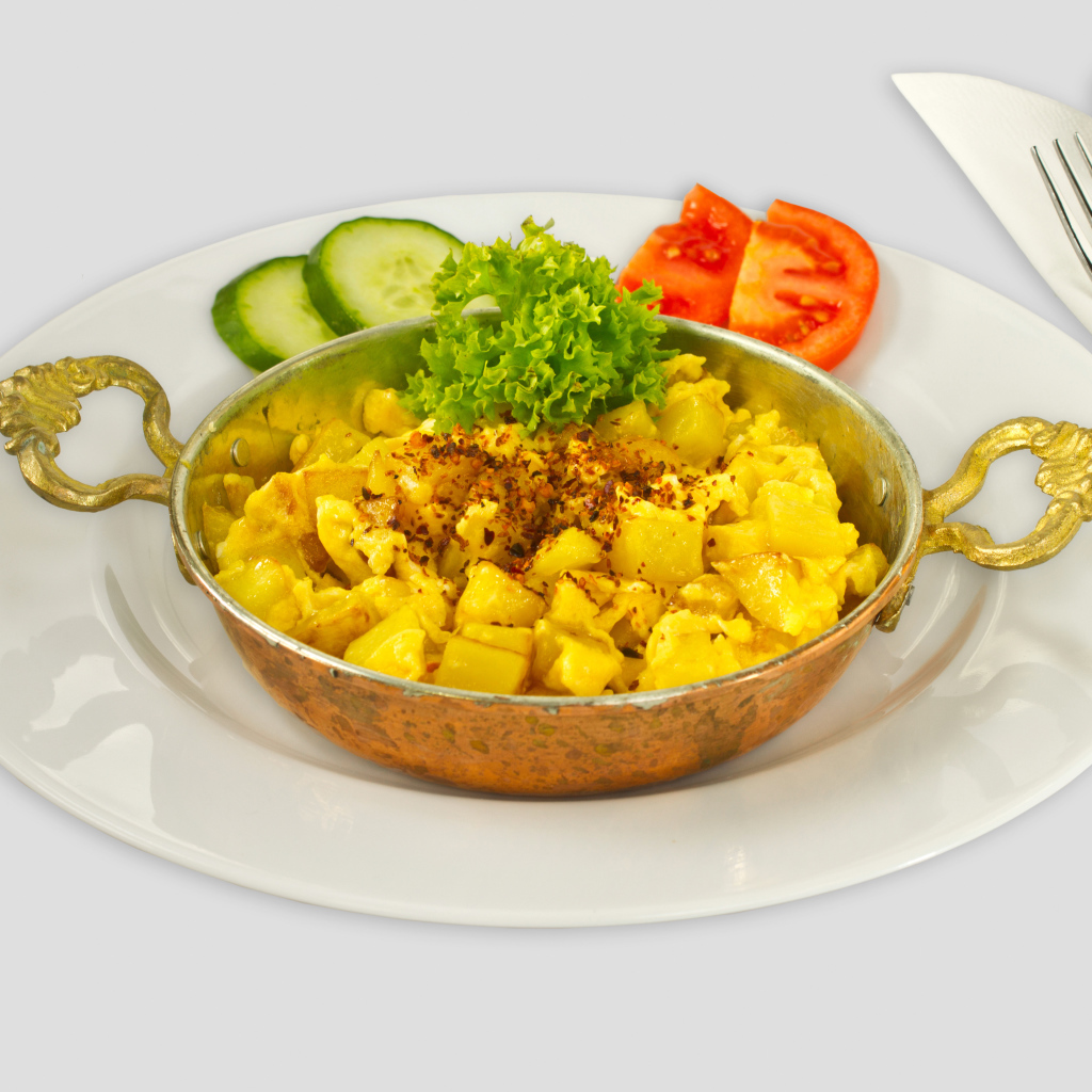 Картофель с овощами на белой тарелке