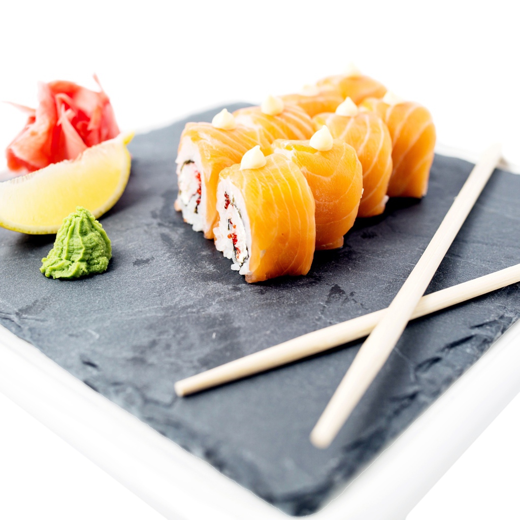 Роллы с красной рыбой на тарелке с палочками